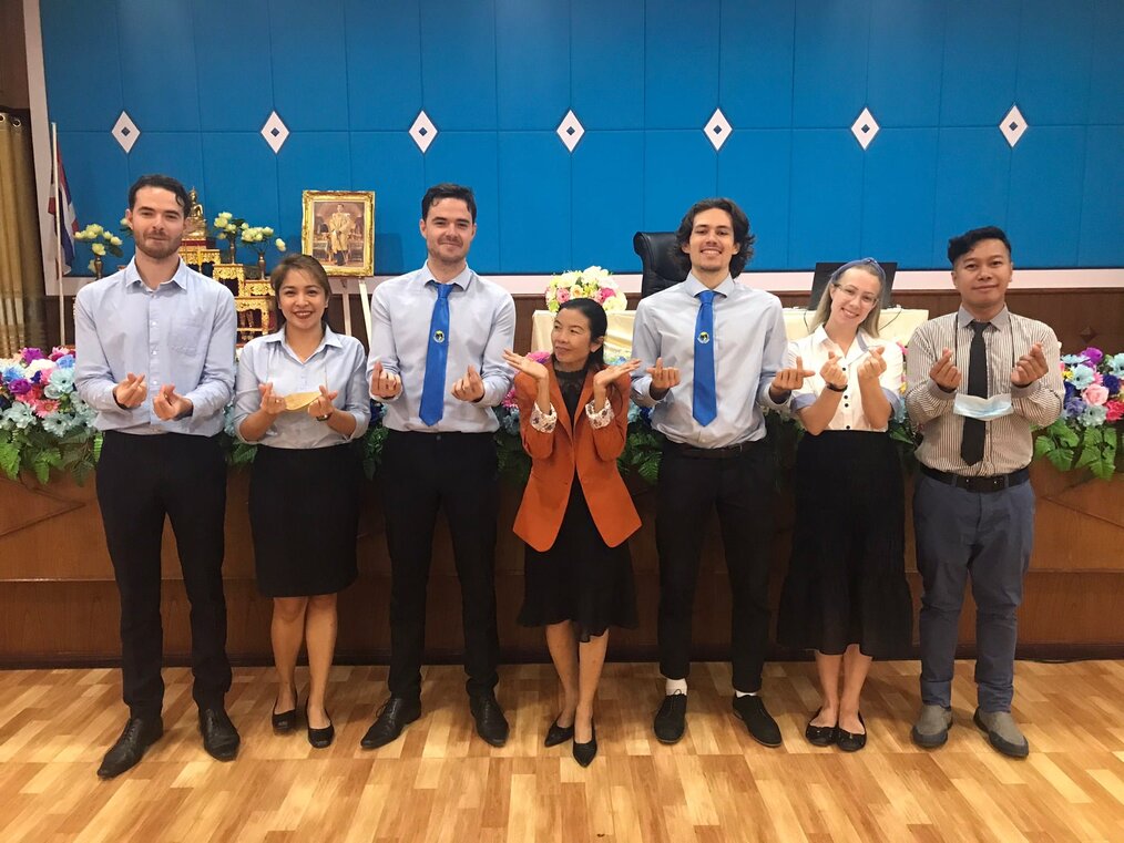 A group of 7 people pose and smile 